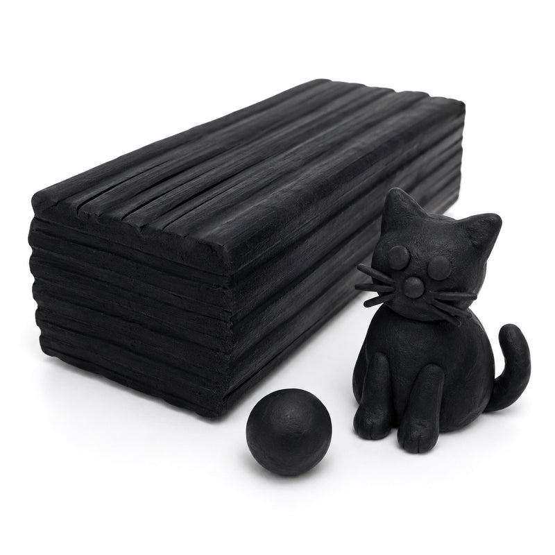 Close-up studio image of Educational Colours black modelling clay block with a handmade black cat sculpture and clay ball on a clean white background highlighting texture and sculpting detail.