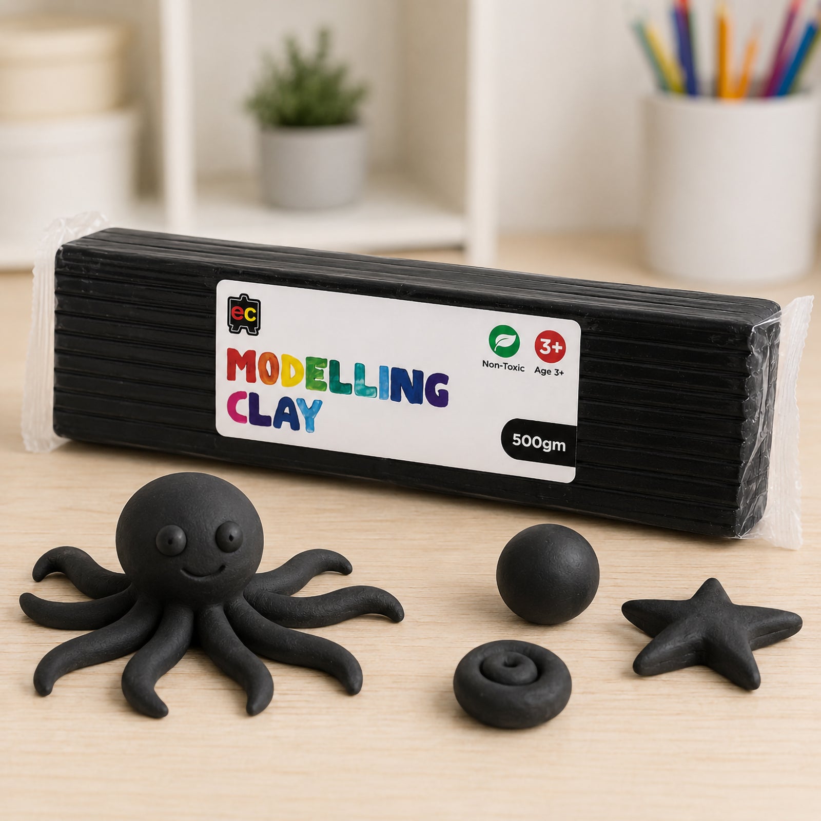 Educational Colours 500g black modelling clay pack displayed on a tabletop beside a handmade black octopus figure and small clay shapes in a creative arts and crafts environment.