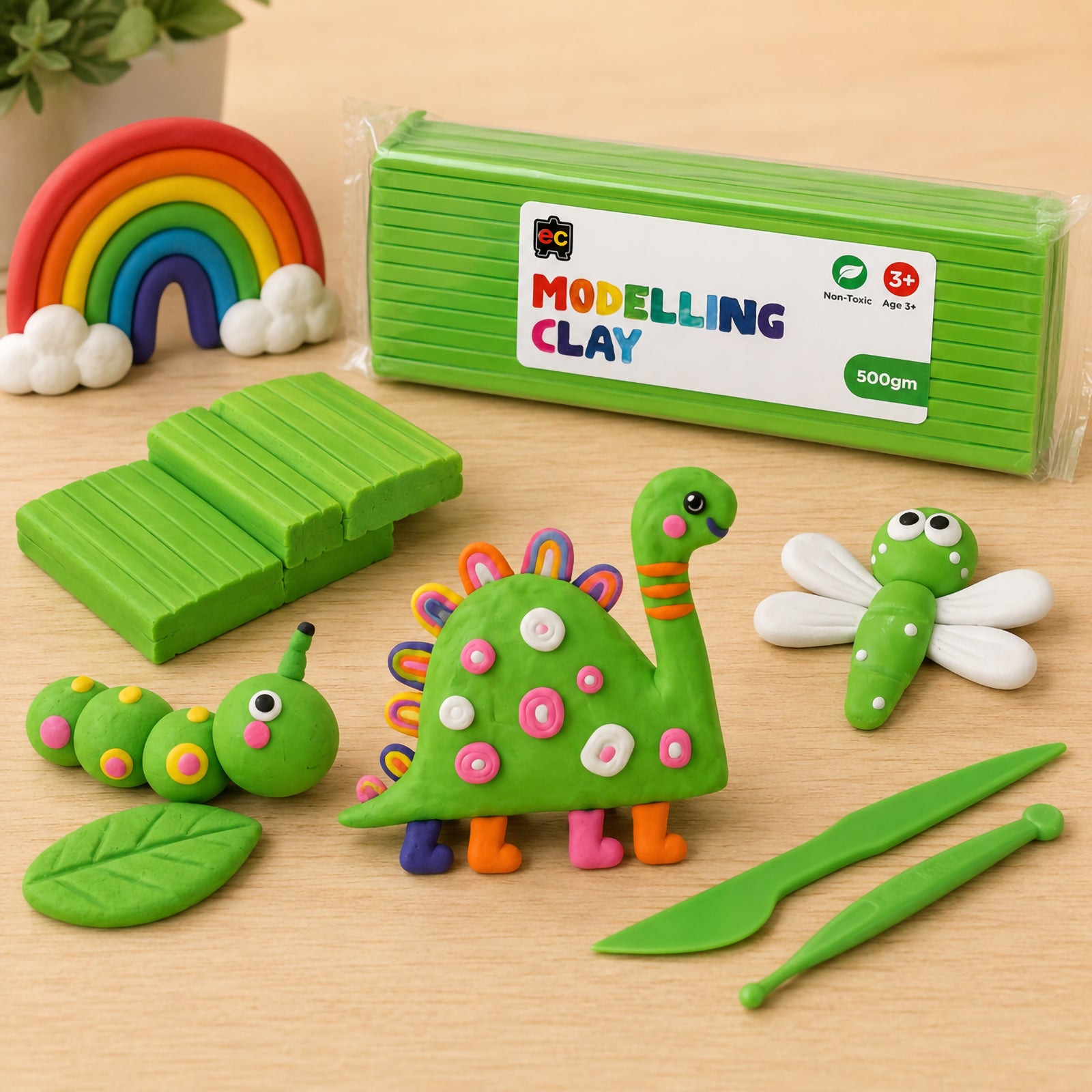Educational Colours Modelling Clay 500g Green with playful clay dinosaur and caterpillar figures, sculpting tools, and rainbow decoration on a clean wooden surface.