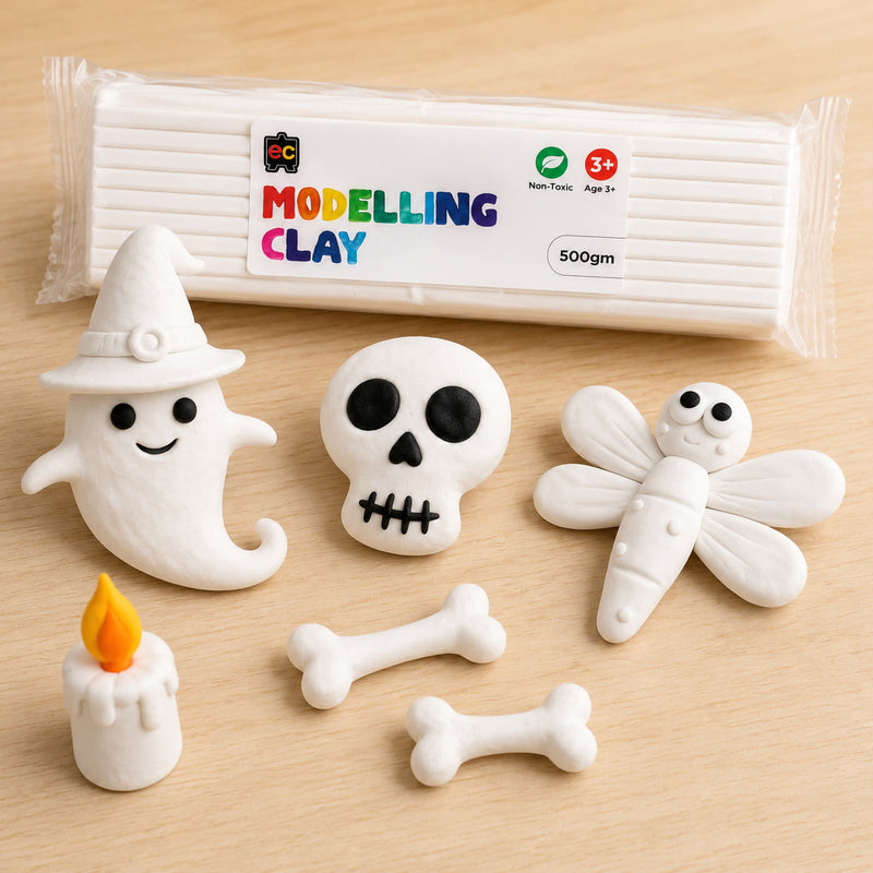 Packaged white modelling clay surrounded by detailed handmade clay Halloween figures including a ghost, skull, bones, and dragonfly in a bright studio setting.