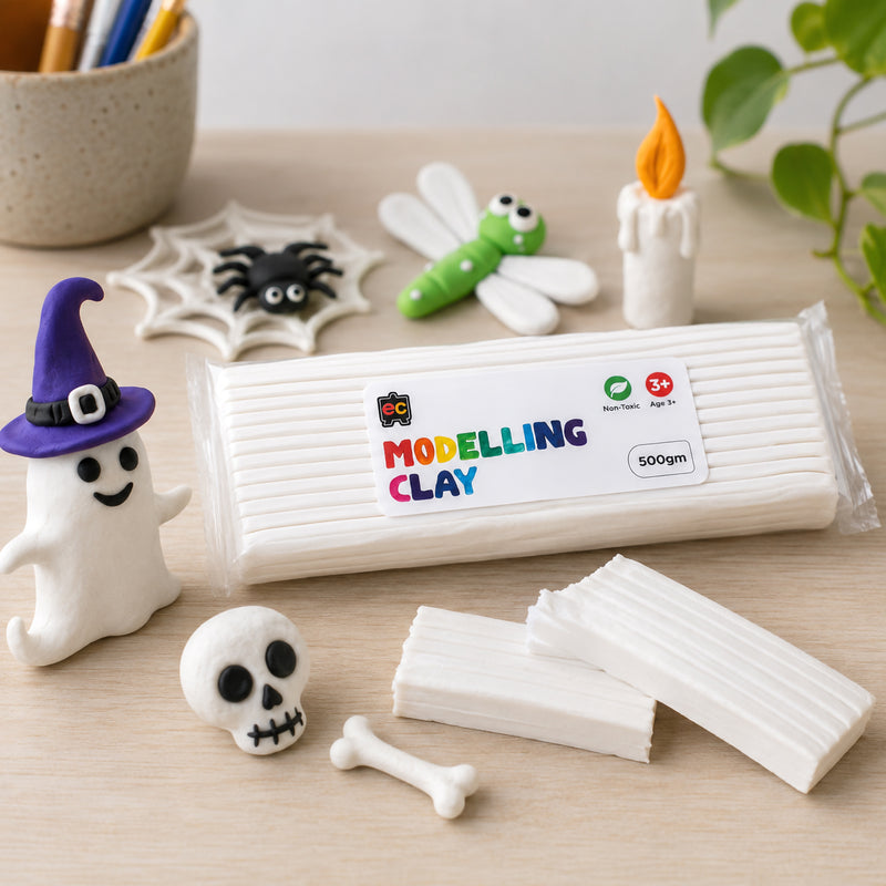 White modelling clay package with Halloween-themed clay creations including a ghost, skull, spider web, dragonfly and candle displayed on a clean wooden surface in a bright studio scene.