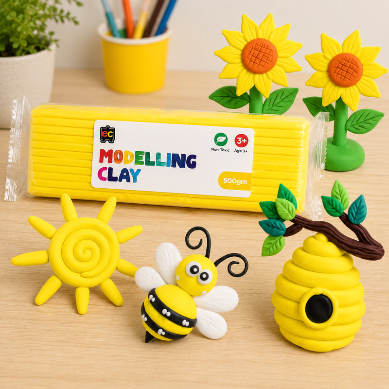 Educational Colours yellow modelling clay pack with detailed handmade clay sunflowers, bee, beehive, and sun arranged on a light wood craft table.