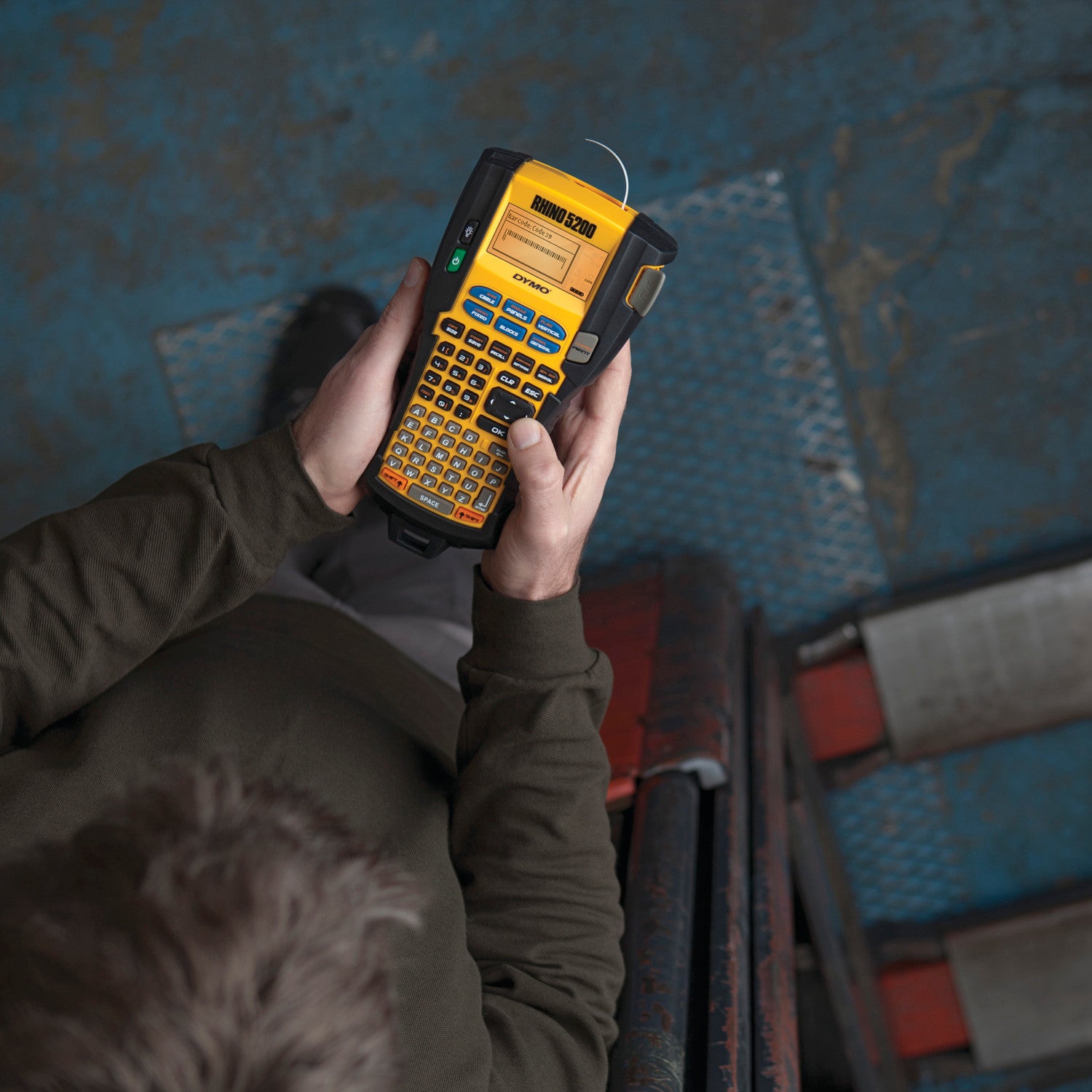 Person holding a label printer in an industrial setting