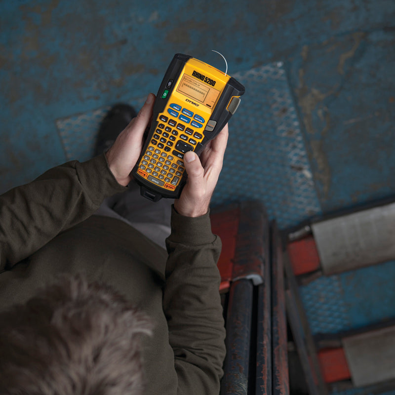 Person holding a label printer in an industrial setting