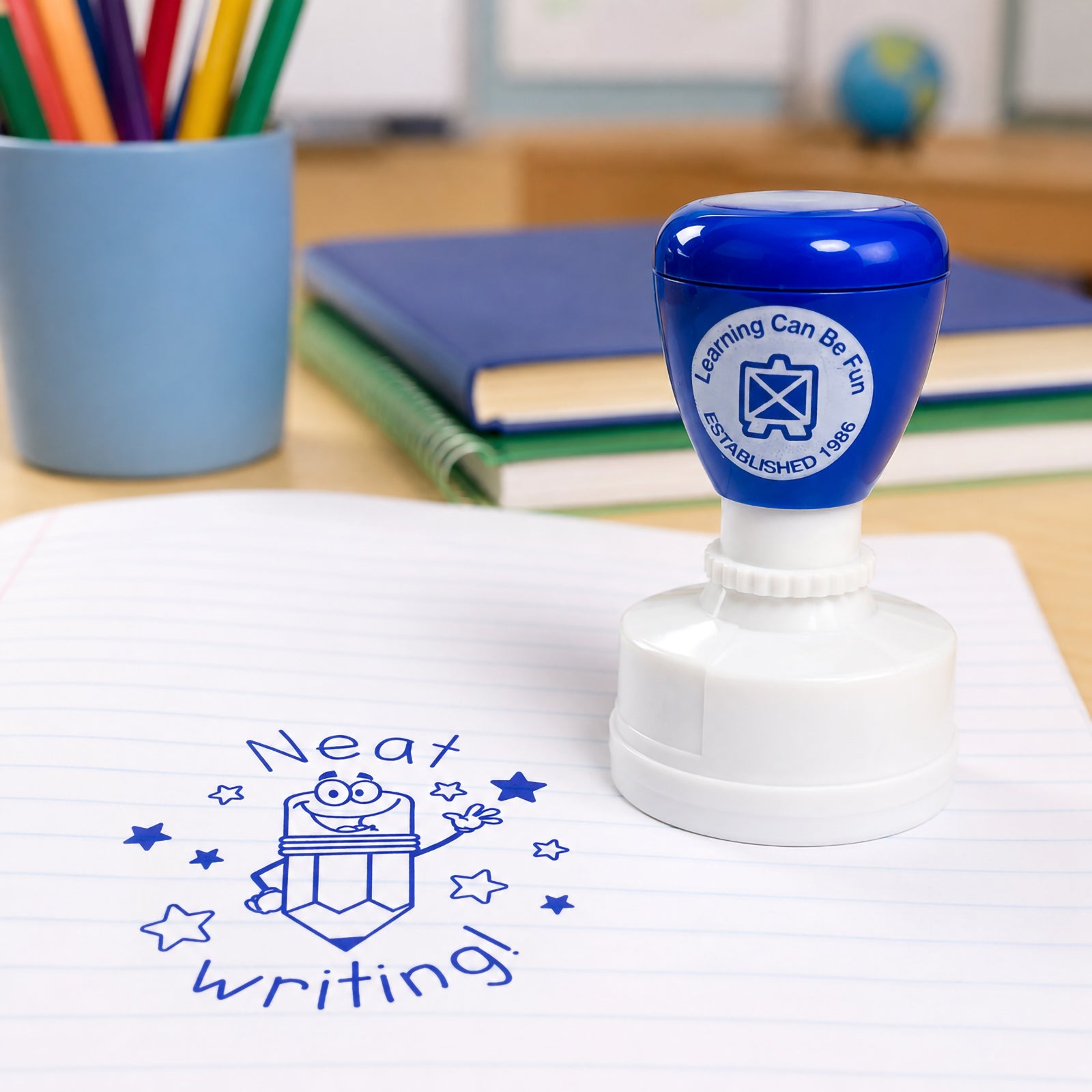 Learning Can Be Fun Neat Writing Merit Stamp displayed on a student workbook with a clear blue Neat Writing impression. The cheerful pencil character and star design create an engaging reward for handwriting achievements in the classroom.