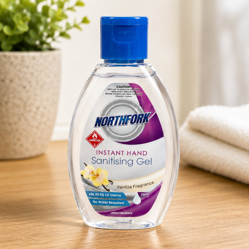 Northfork Instant Hand Sanitising Gel 70ml standing on a timber benchtop beside folded towels and a potted plant in a bright home environment. The clean setting emphasises personal hygiene, everyday convenience and the pleasant vanilla fragrance.
