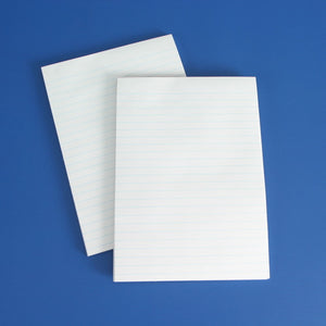 Two white Olympic A5 office pads lying at an angle on a blue background, pages printed with light blue horizontal ruled lines
