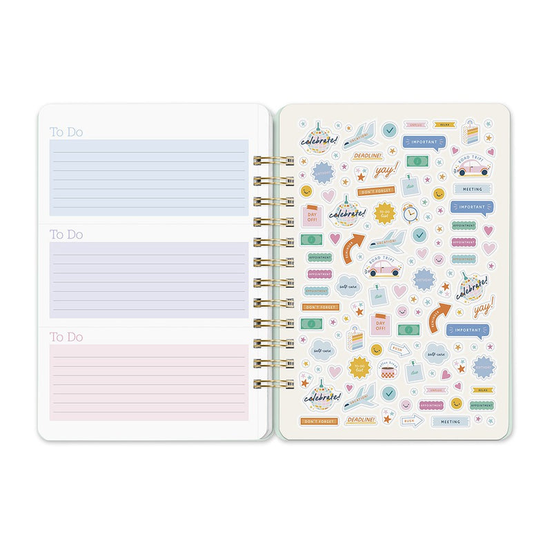 Orange Circle 2027 Do-It-All Diary 146 x 210mm Week To View Fruit And Flora shown from a further angle, the Fruit And Flora design, a bright botanical mix of fruit and flowers, showing the cover corners and closure detail.