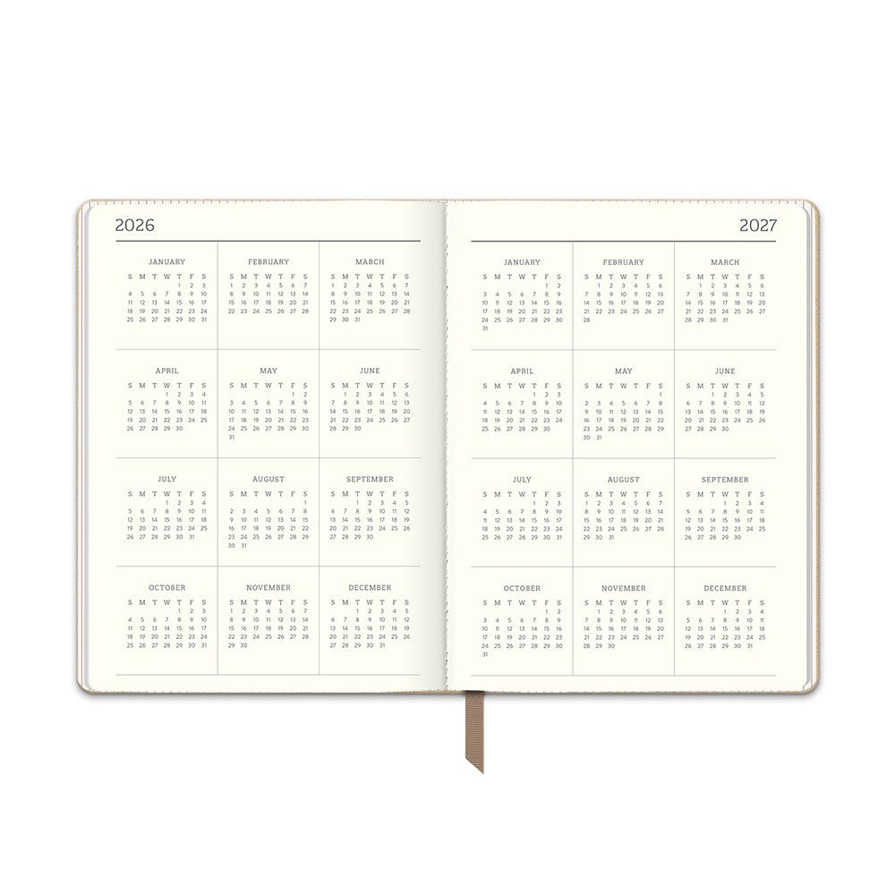 Orange Circle 2027 Medium Dual-Textured Diary 142 x 193mm Week To View Dots On Chai shown at a three quarter angle, the Dots On Chai design, a fine dot on a warm chai neutral, highlighting the cover finish and binding edge.