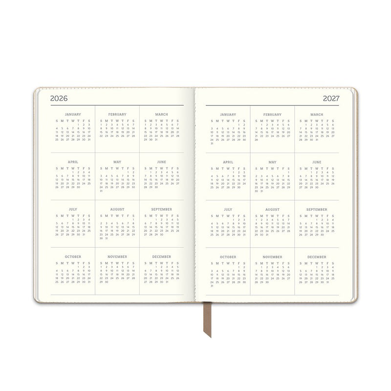 Orange Circle 2027 Medium Dual-Textured Diary 142 x 193mm Week To View Dots On Chai shown at a three quarter angle, the Dots On Chai design, a fine dot on a warm chai neutral, highlighting the cover finish and binding edge.