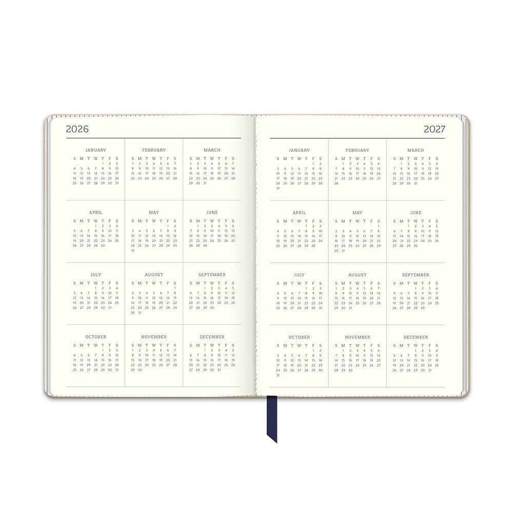 Orange Circle 2027 Medium Dual-Textured Diary 142 x 193mm Week To View Dots On Navy shown at a three quarter angle, the Dots On Navy design, a fine cream dot scattered across deep navy, highlighting the cover finish and binding edge.