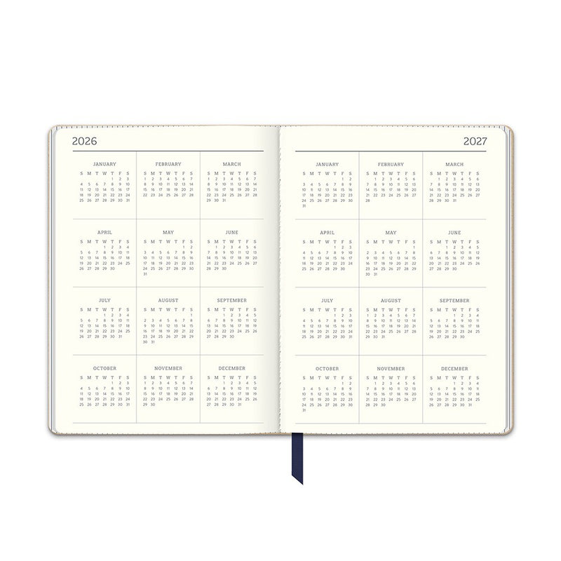 Orange Circle 2027 Medium Dual-Textured Diary 142 x 193mm Week To View Dots On Navy shown at a three quarter angle, the Dots On Navy design, a fine cream dot scattered across deep navy, highlighting the cover finish and binding edge.