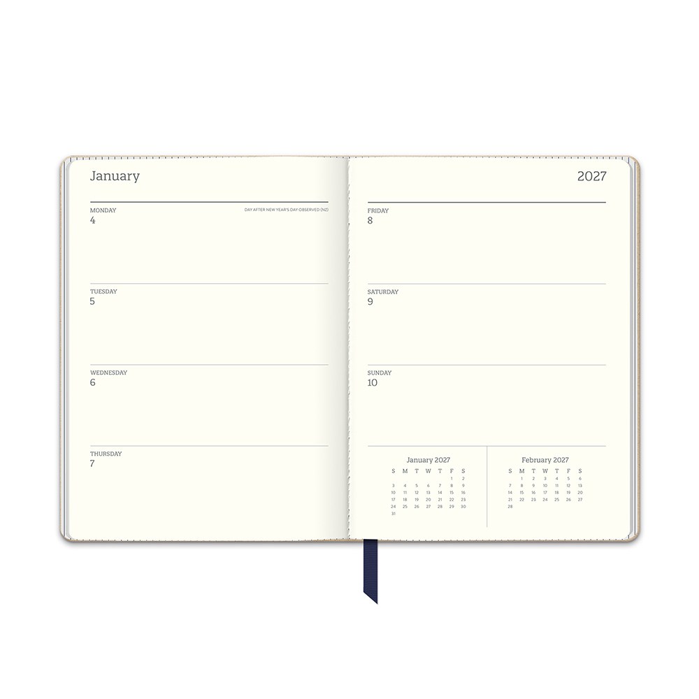 Orange Circle 2027 Medium Dual-Textured Diary 142 x 193mm Week To View Dots On Navy shown from a second angle, the Dots On Navy design, a fine cream dot scattered across deep navy, with the spine and page block edge visible.