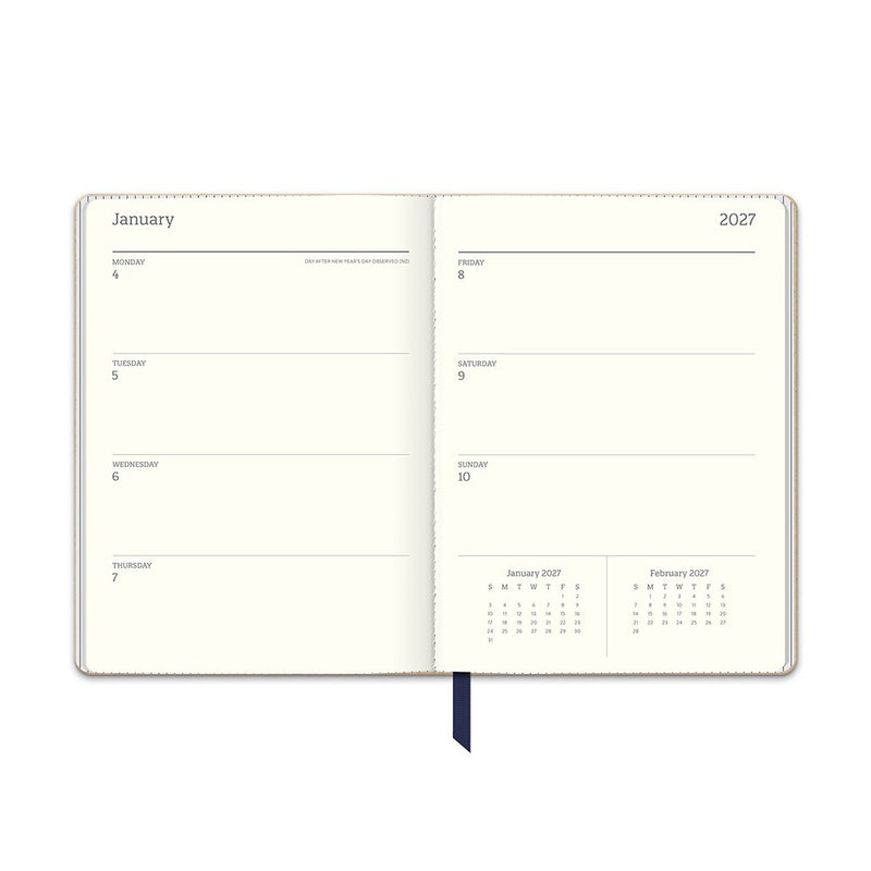 Orange Circle 2027 Medium Dual-Textured Diary 142 x 193mm Week To View Dots On Navy shown from a second angle, the Dots On Navy design, a fine cream dot scattered across deep navy, with the spine and page block edge visible.