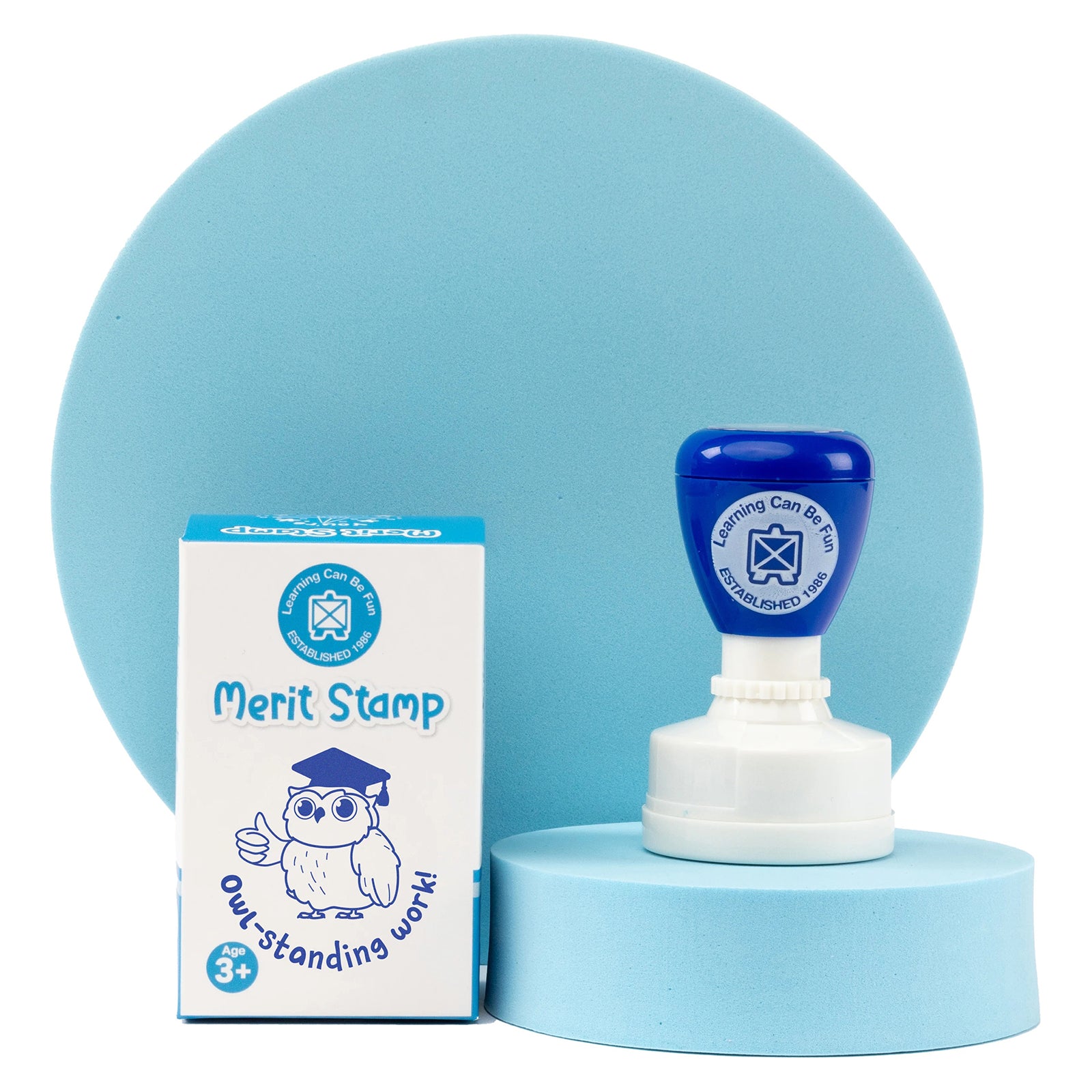 Retail packaging and merit stamp presented together on a display platform. The blue themed educational reward stamp highlights a fun and engaging way to celebrate student success, learning milestones and exceptional effort.