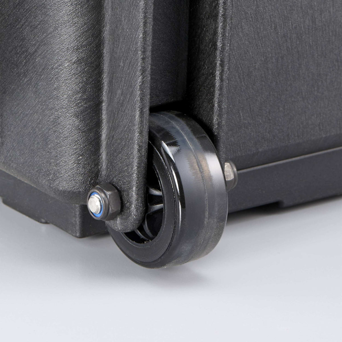 Close-up of a wheel fitted at the base of a MAX520 case, showing the steel pin and black tyre