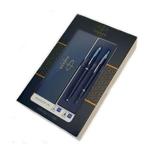 Parker IM gift box with a clear window showing a black lacquer fountain pen and ballpoint pen with chrome trim on a navy tray, beside a navy panel printed Parker Est. 1888
