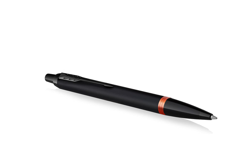 Parker IM Vibrant Rings ballpoint pen in satin black lying at an angle on white, showing the Flame Orange ring, the black clip and the ballpoint tip