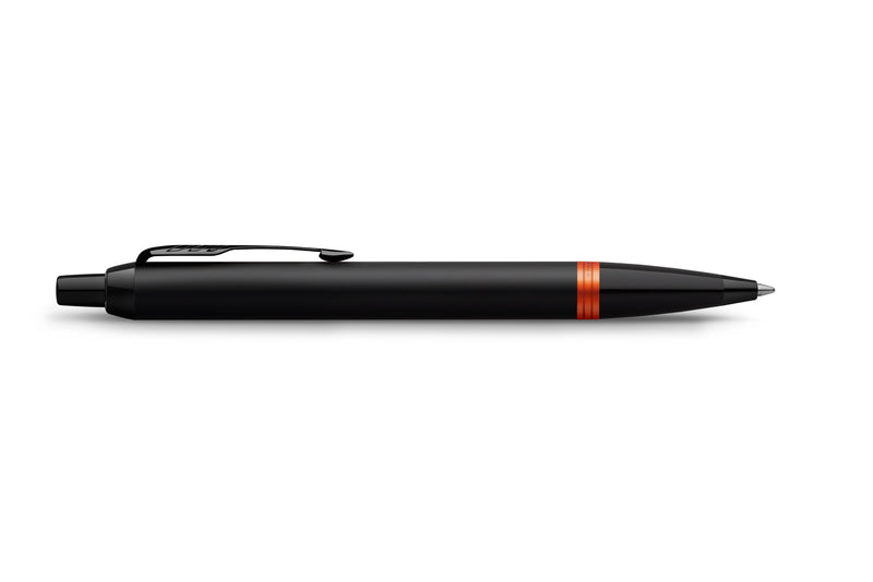 Side profile of the Parker IM Vibrant Rings Flame Orange ballpoint pen with the clip uppermost, showing the black push button, satin black barrel and orange ring