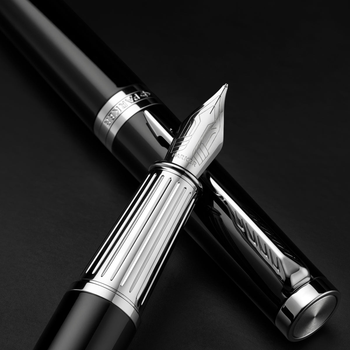 Close-up on a dark background of the nib and ribbed engraved section of the black Ingenuity