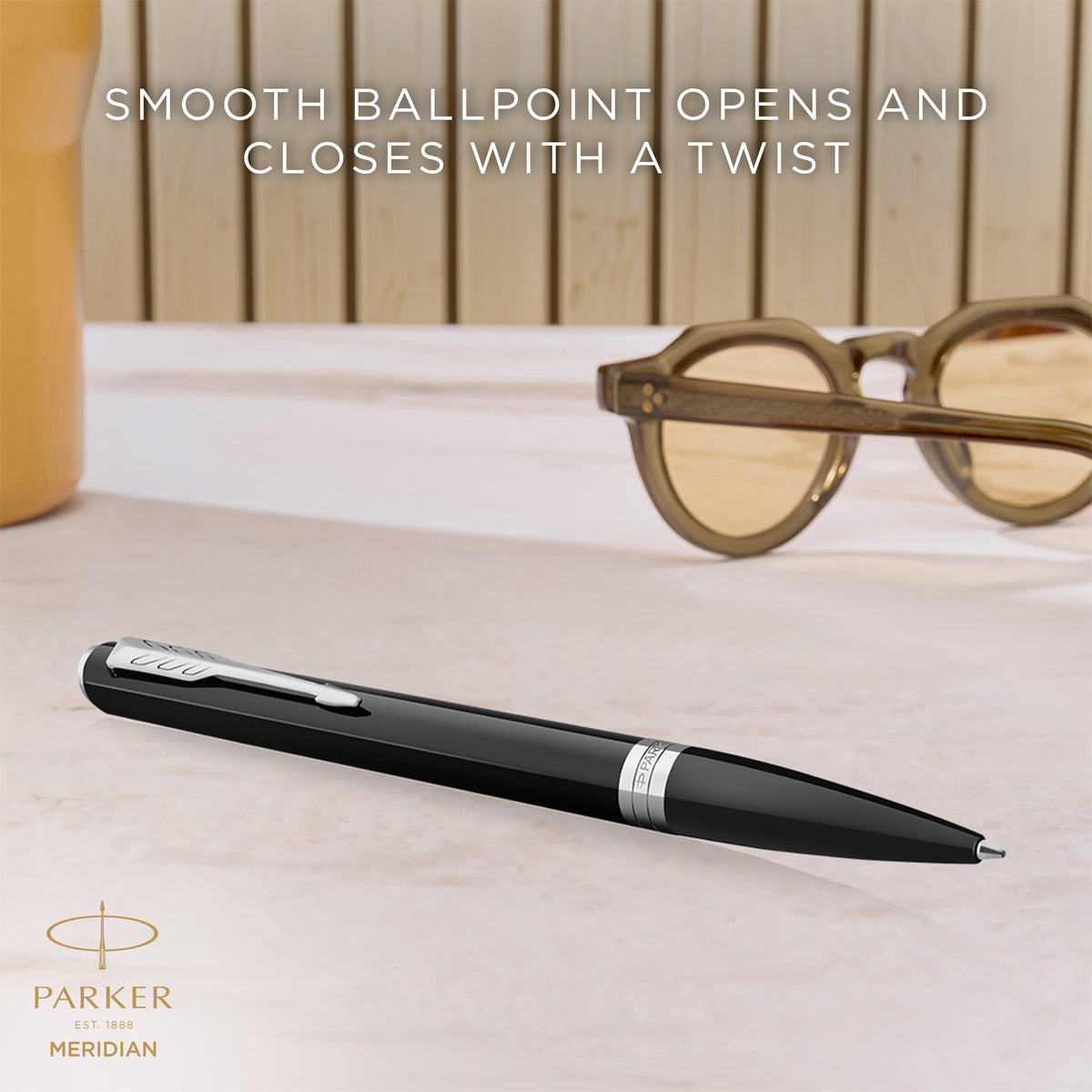Black Meridian ballpoint resting on a desk, with Parker's caption that the smooth ballpoint opens and closes with a twist