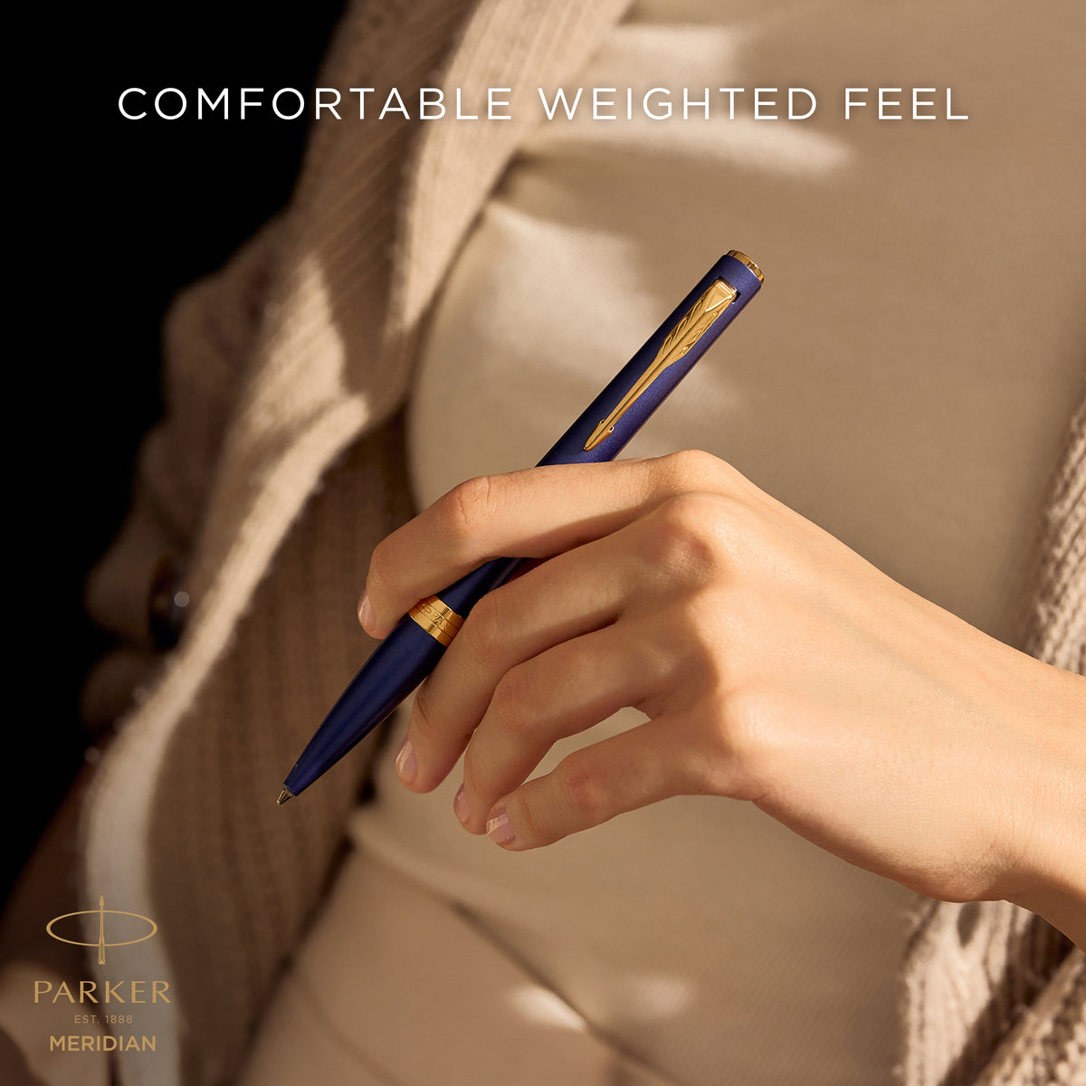Hand writing with the blue Meridian ballpoint, captioned comfortable weighted feel