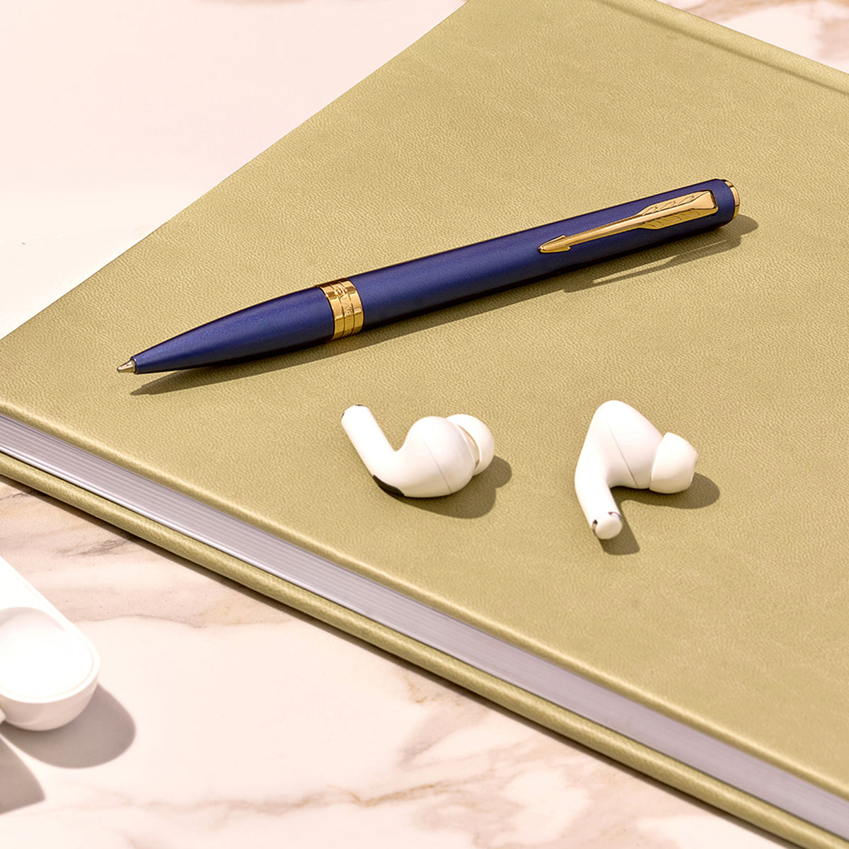 Blue Meridian ballpoint in a styled desk setting, showing the gold clip and centre band