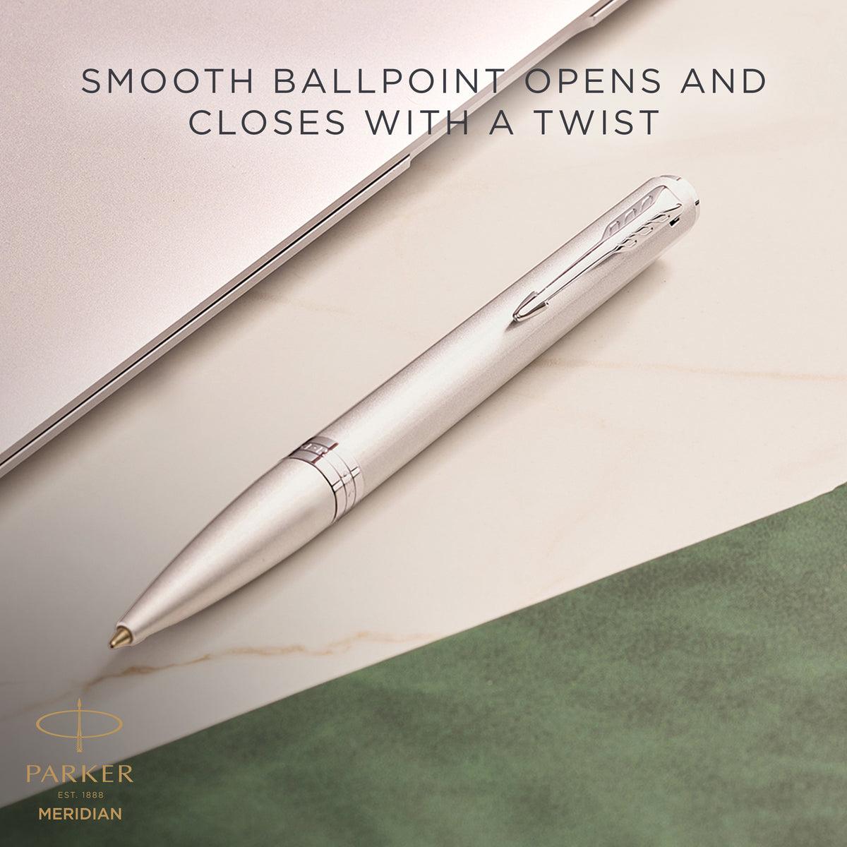 Chrome Meridian ballpoint resting on a desk, with Parker's caption that the smooth ballpoint opens and closes with a twist