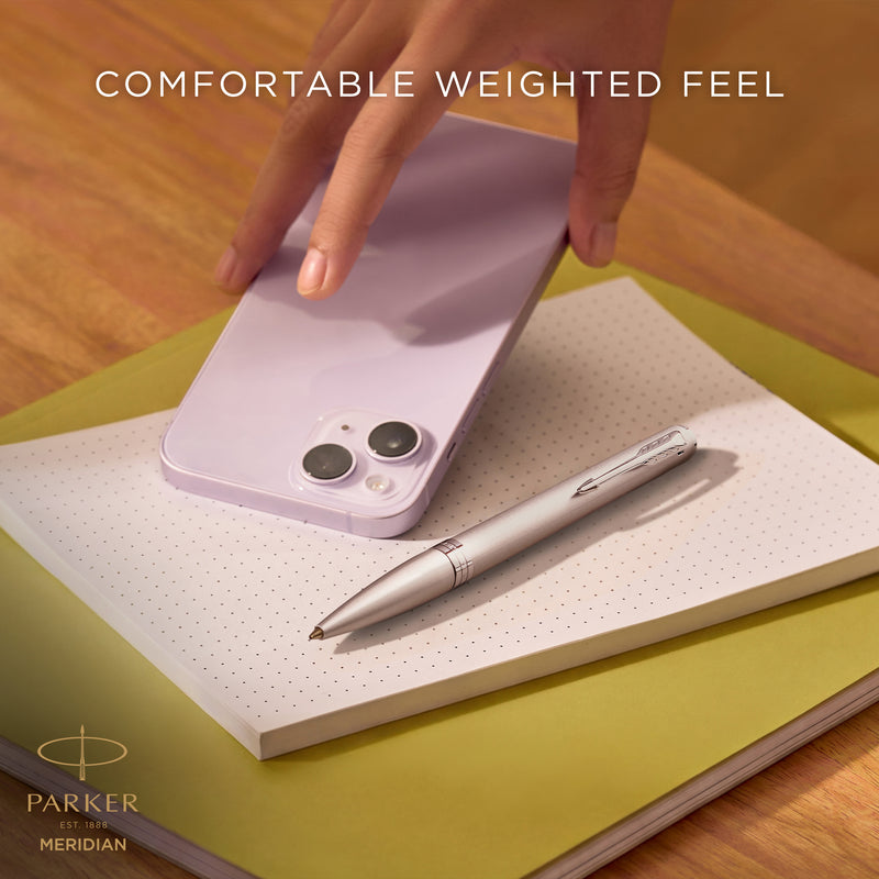 Hand writing with the chrome Meridian ballpoint, captioned comfortable weighted feel