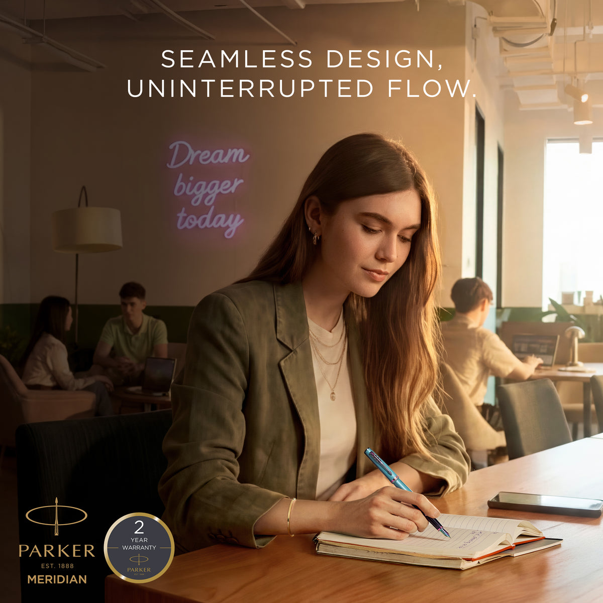 Woman journaling at a cafe table with a Parker Meridian ballpoint, captioned seamless design, uninterrupted flow