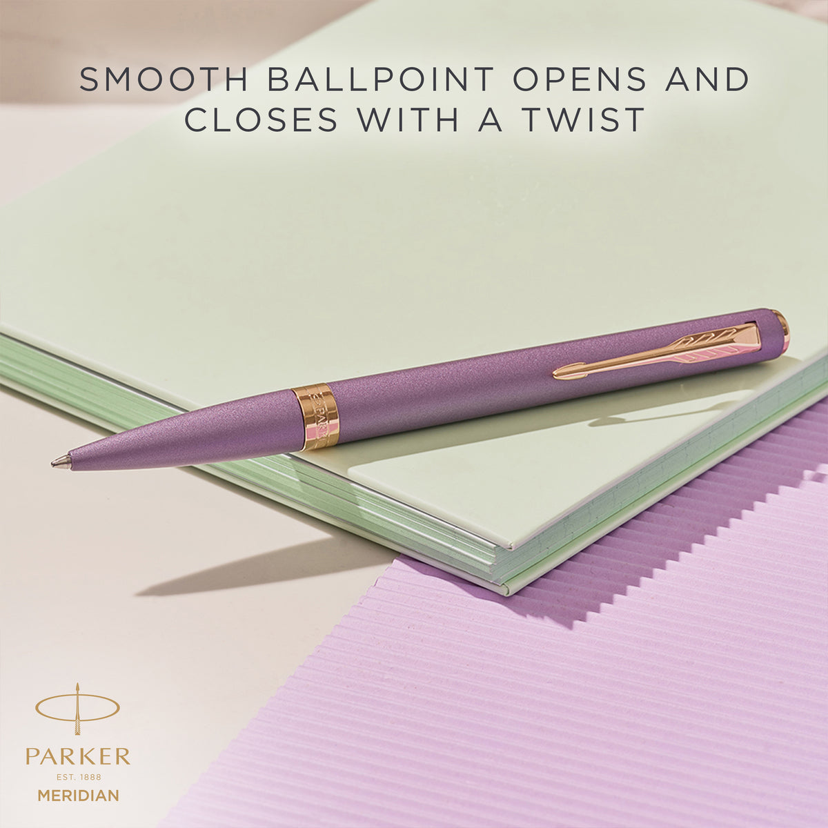 Purple Meridian ballpoint resting on a desk, with Parker's caption that the smooth ballpoint opens and closes with a twist