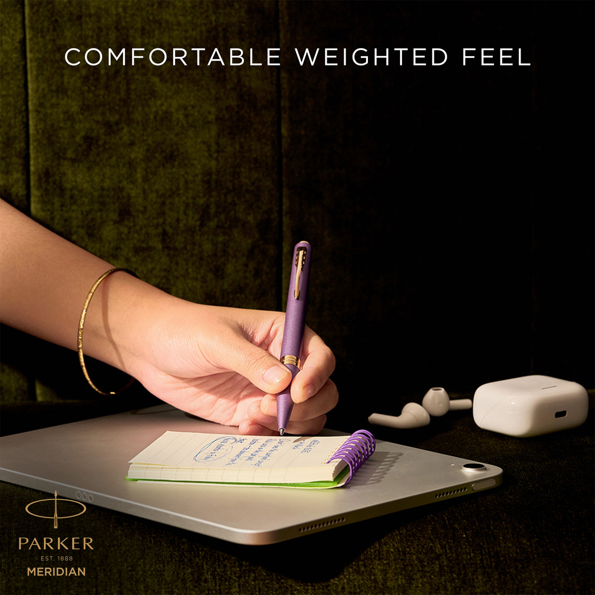 Hand writing with the purple Meridian ballpoint, captioned comfortable weighted feel