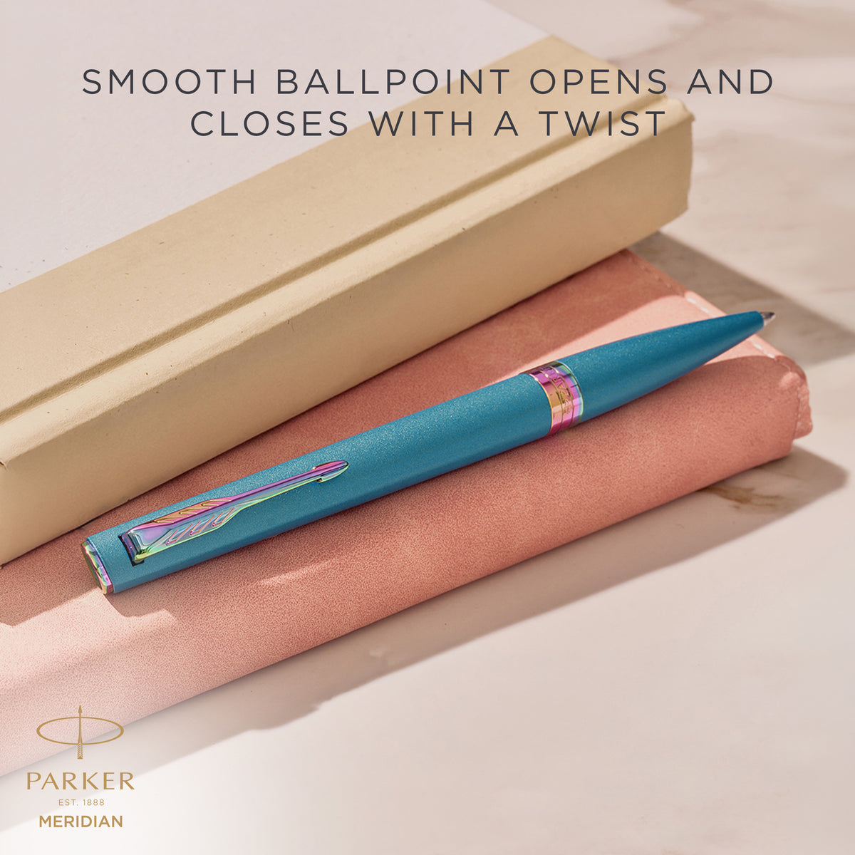 Teal Meridian ballpoint resting on a desk, with Parker's caption that the smooth ballpoint opens and closes with a twist