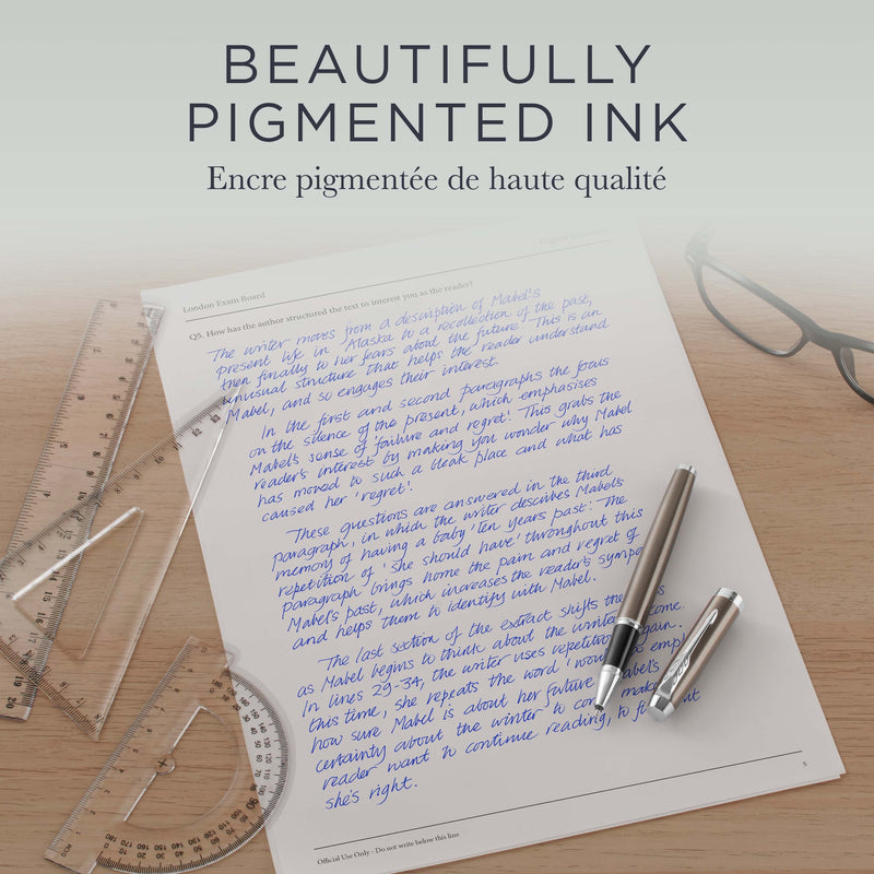 Grey Parker pen on a lined page of blue handwriting beside rulers, BEAUTIFULLY PIGMENTED INK heading