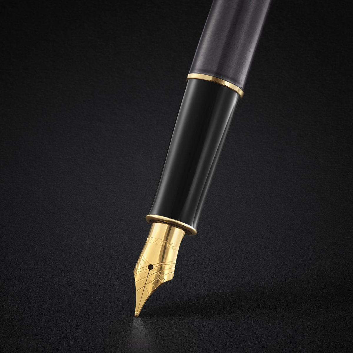 Close-up of the gold-coloured nib with Parker engraving below a black section and gold ring