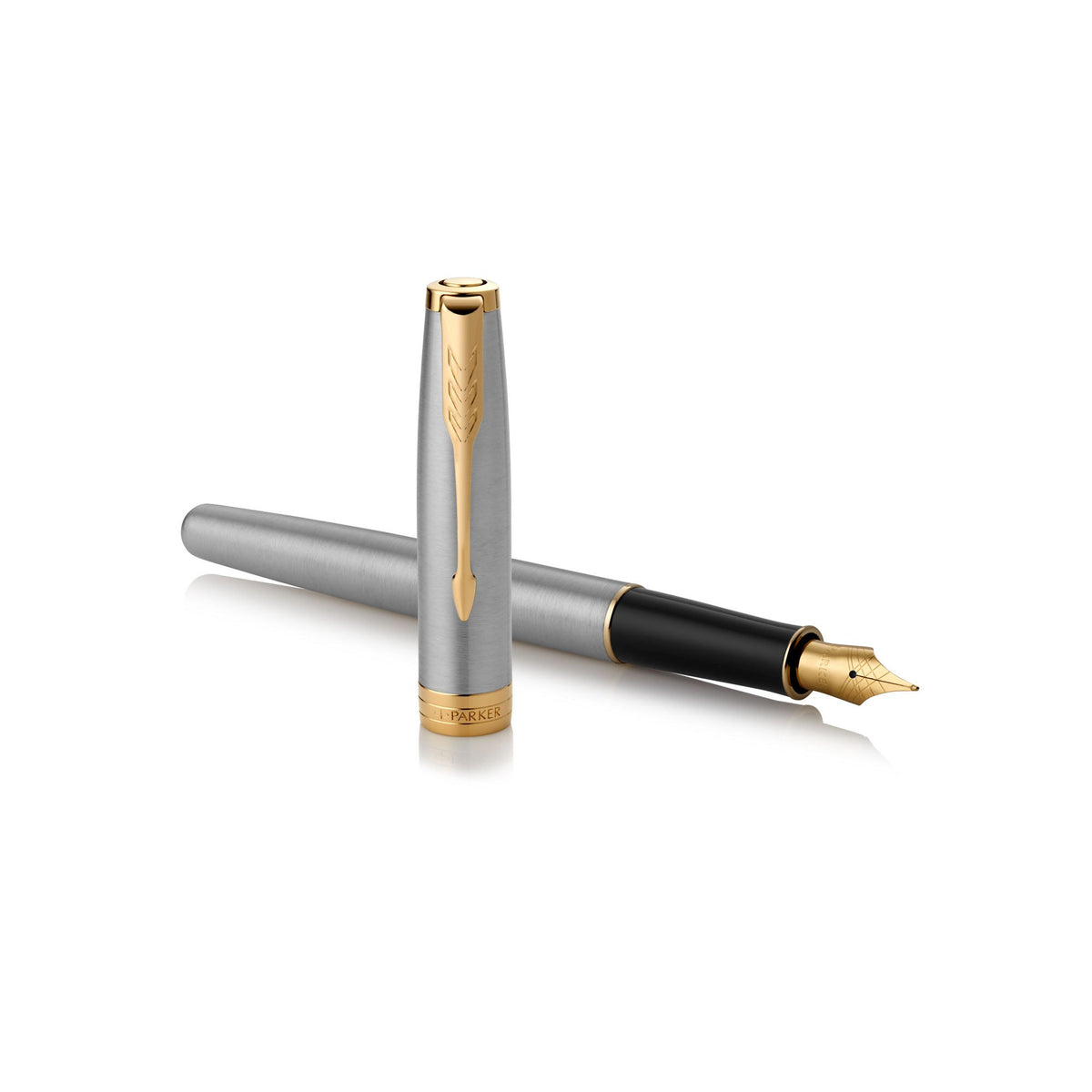 Uncapped steel and gold Sonnet lying across its upright cap with the nib to the right