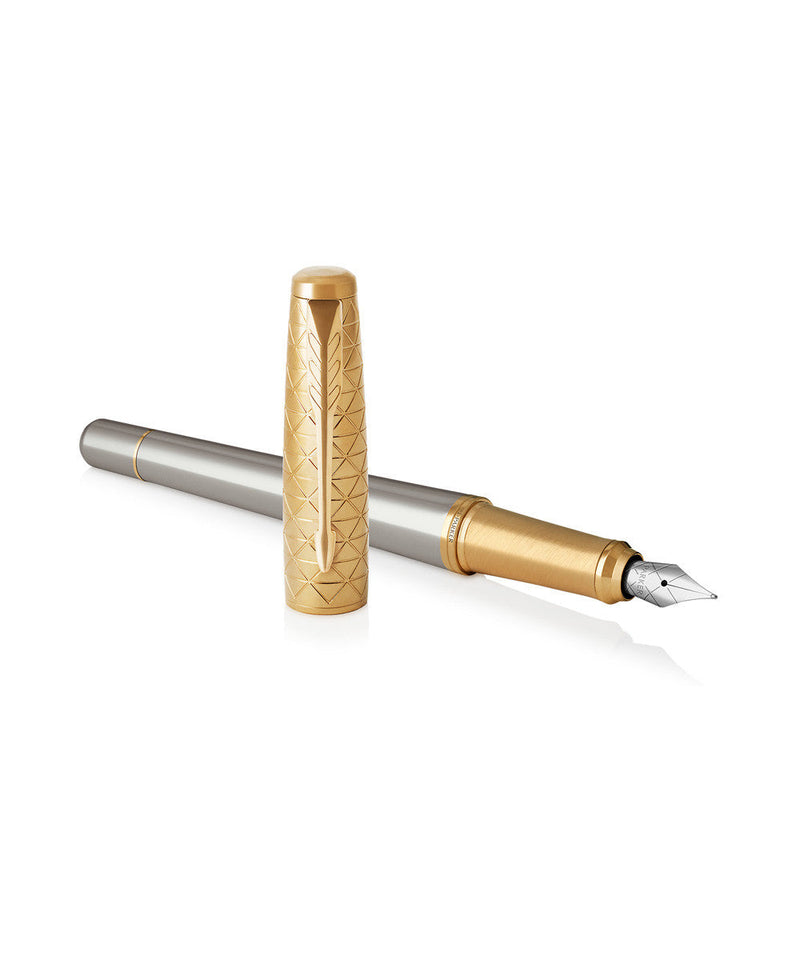 Parker Urban Premium fountain pen with the engraved gold cap stood upright beside the uncapped pen, showing the medium stainless steel nib and gold grip ring.