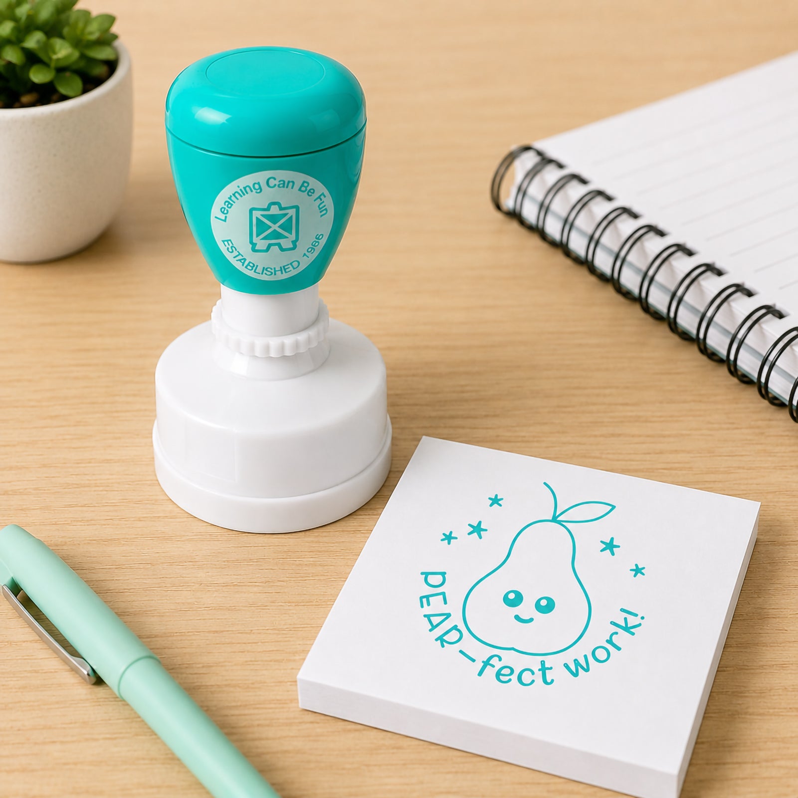 Teacher reward stamp positioned next to a note pad and desk accessories. The smiling pear illustration and Pear-fect Work message create an engaging feedback tool that motivates students and recognises effort in a fun and memorable way.