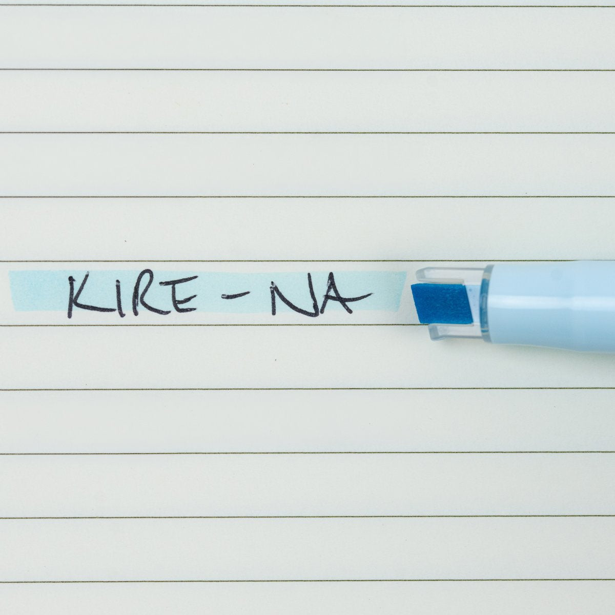 Pilot Kire-Na pale blue dual tip highlighter in use on a page of printed notes, the broad chisel tip laying a straight band of pale blue across a line of text