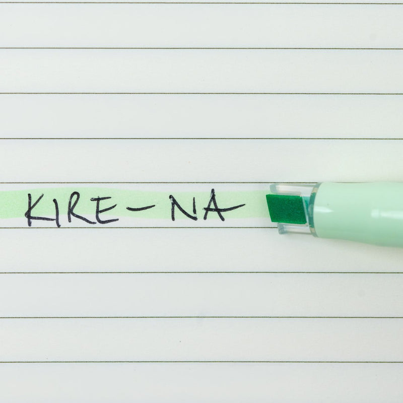 Pilot Kire-Na pale green dual tip highlighter in use on a page of printed notes, the broad chisel tip laying a straight band of pale green across a line of text