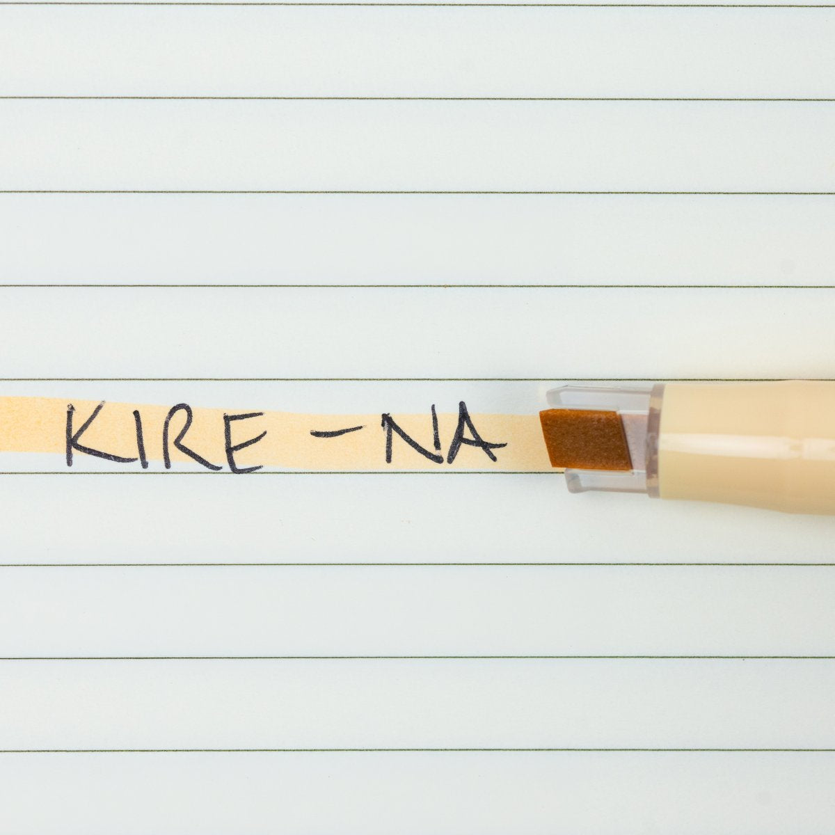Pilot Kire-Na pale orange dual tip highlighter in use on a page of printed notes, the broad chisel tip laying a straight band of pale orange across a line of text