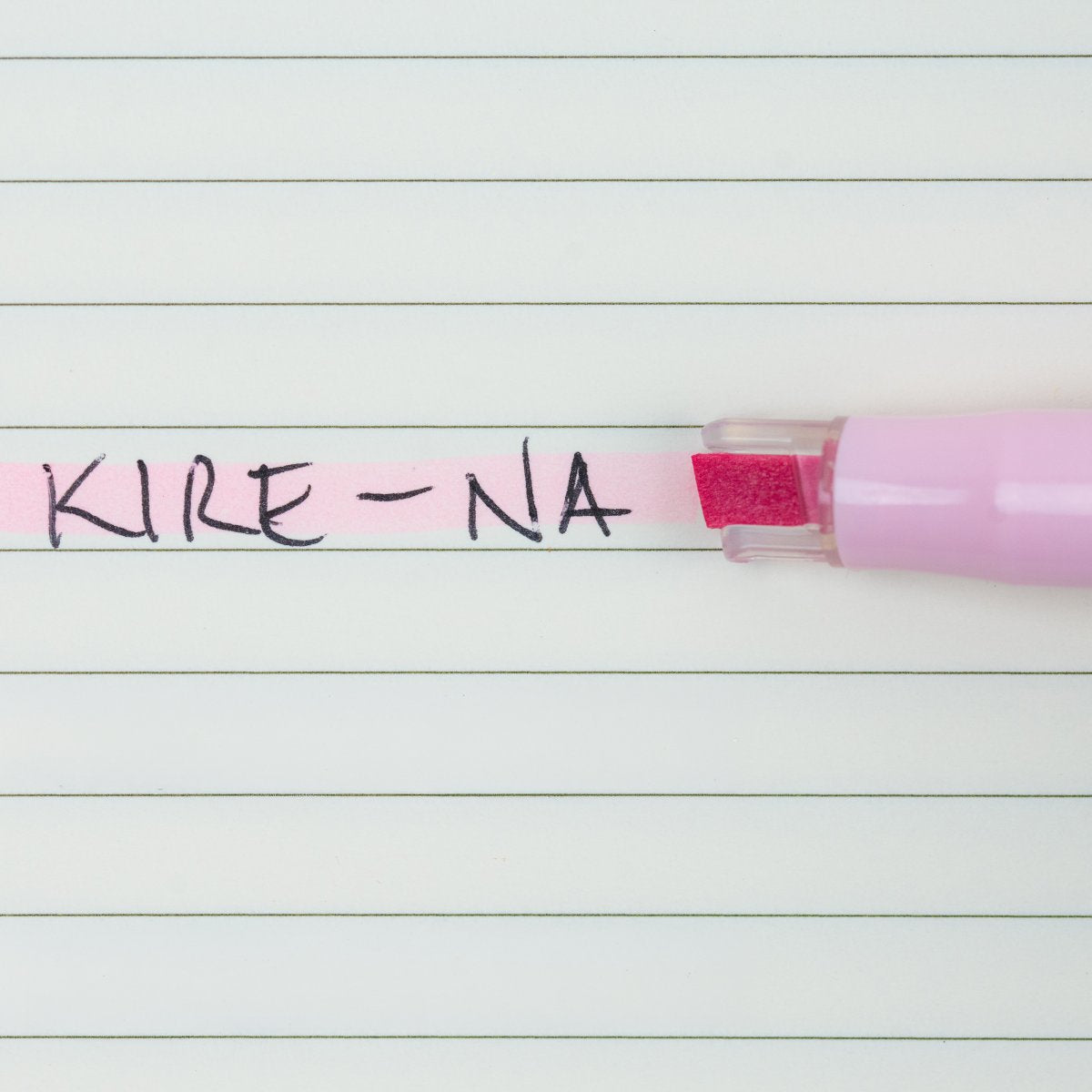Pilot Kire-Na pale pink dual tip highlighter in use on a page of printed notes, the broad chisel tip laying a straight band of pale pink across a line of text