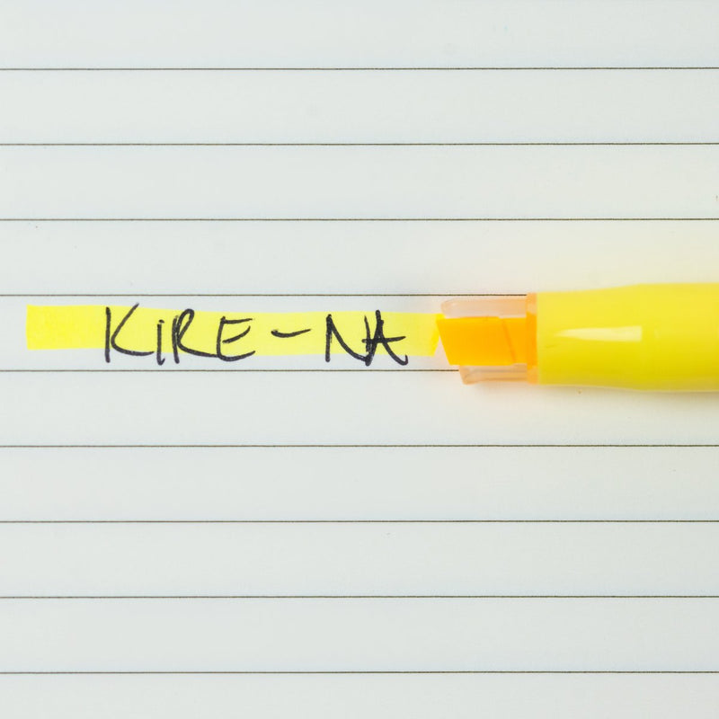 Pilot Kire-Na yellow dual tip highlighter in use on a page of printed notes, the broad chisel tip laying a straight band of yellow across a line of text