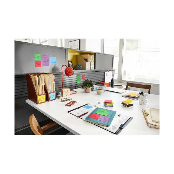 Office workstation with assorted coloured square notes on a grey partition and desk, a general Post-it scene rather than this lined pack
