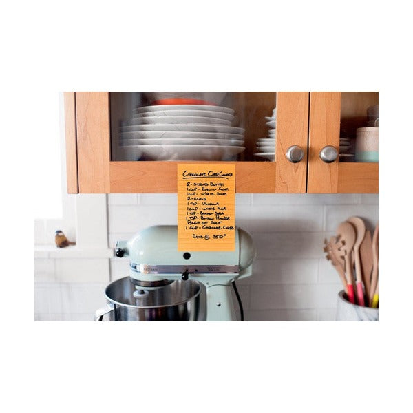 Orange lined Post-it with a handwritten recipe stuck to a kitchen cabinet above a stand mixer