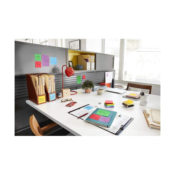 Office workstation with assorted coloured square notes on a grey partition and desk, a general Post-it scene