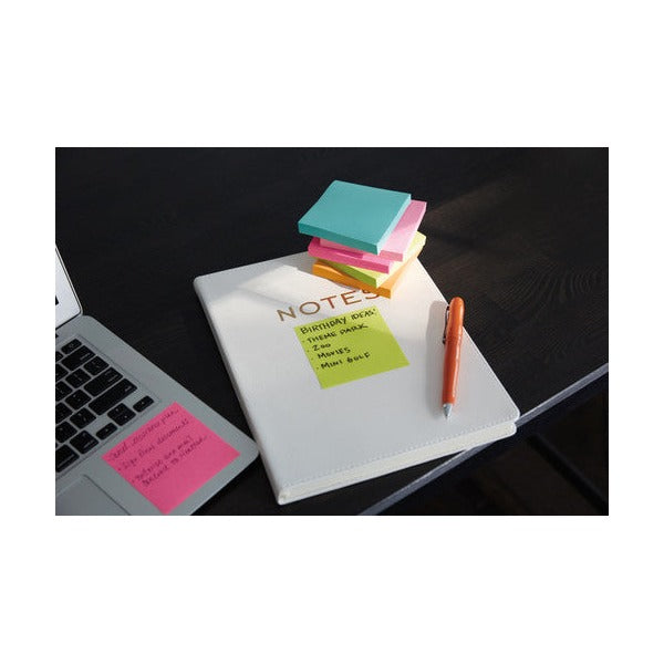 Miami coloured square notes stacked on a white notebook with a lime note listing ideas, beside a laptop