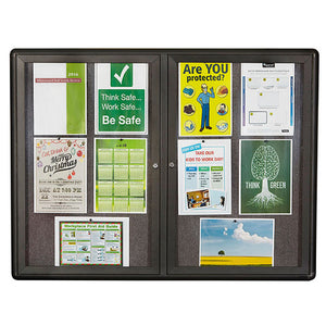 Landscape Quartet enclosed notice board with doors side by side, a dark graphite frame around grey fabric holding a Christmas party flyer, a calendar, safety posters and a first aid guide