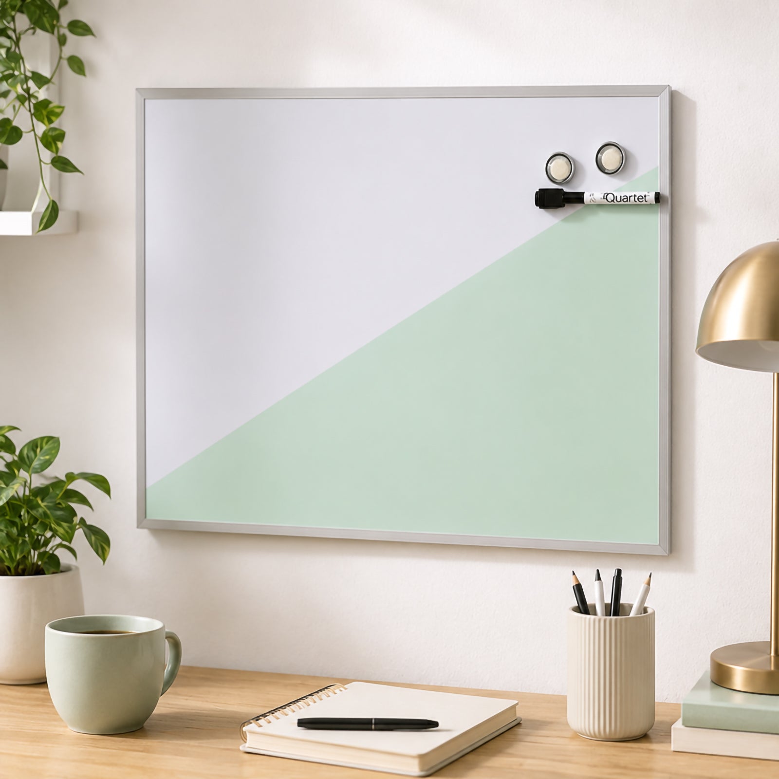 The Quartet Geo Magnetic Whiteboard Teal 430 x 580mm displayed on a contemporary office wall with a minimalist workspace below. The geometric teal design creates an attractive focal point while providing a spacious magnetic dry erase surface for planning and communication.