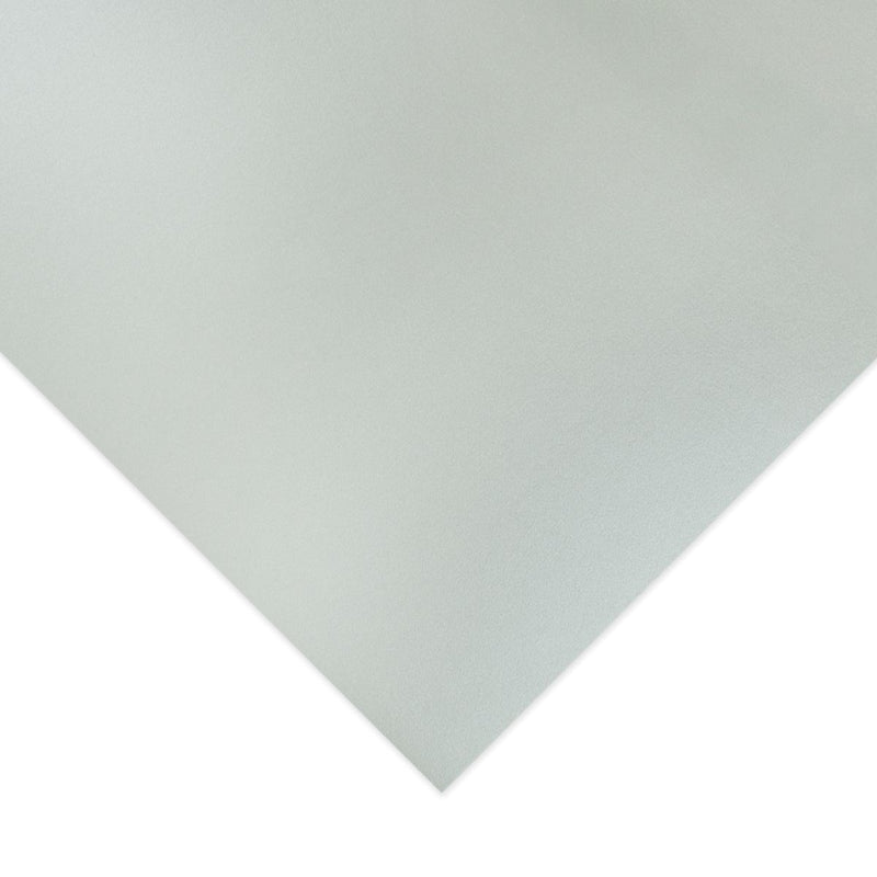 Corner of a sheet of Quill Metallique Board A3 in Silver Shadow photographed close up, showing the board edge and a pale grey finish